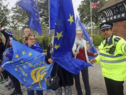 Un policía desvía a los manifestantes concentrados este jueves ante la residencia de Wirral (Reino Unido) donde se han reunido Johnson y Varadkar. En vídeo, las declaraciones del irlandés tras el encuentro.