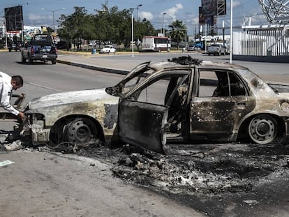 Un policía frente a un vehículo quemado, este viernes en Culiacán.