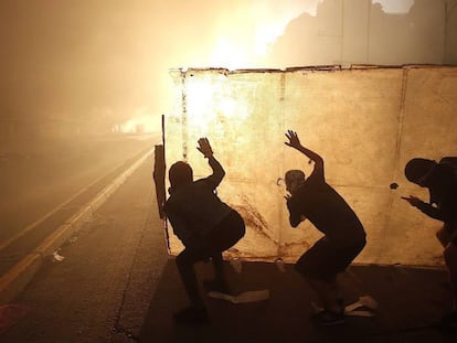 Manifestantes protestan el lunes contra el Gobierno de Sebastián Piñera, en Santiago de Chile. En vídeo, el presidente de Chile admite que la violencia no permitirá la organización de ambos eventos.