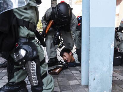 La policía de Hong Kong detiene a un joven, este lunes. En vídeo, un agente dispara a dos manifestantes (Advertencia: imágenes impactantes).