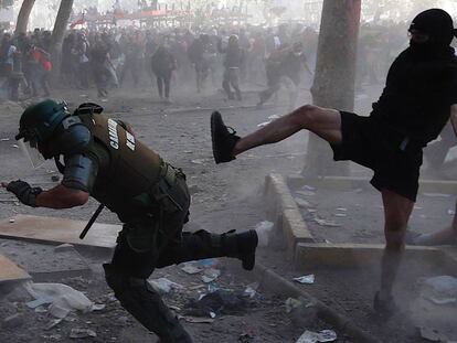 Manifestantes y carabineros se enfrentan durante la manifestación en Santiago, este martes.