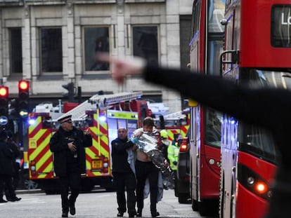 Un agente de policía ayuda a un herido cerca del puente de Londres, este viernes. En vídeo, imágenes de la actuación policial.