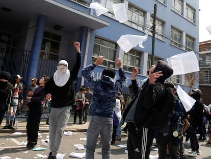 Manifestantes tiran papeles al aire durante una protesta en una universidad en Valparaiso.