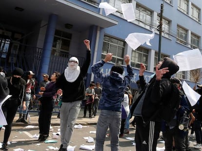 Manifestantes tiran papeles al aire durante una protesta en una universidad en Valparaiso.