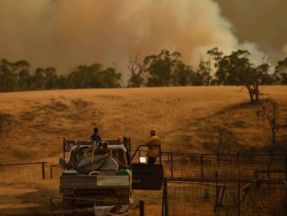 Bomberos de Tumurumba, en Nueva Gales del Sur, observan la proximidad de un frente de fuego a una granja. En vídeo, manifestaciones en toda Australia por la gesión de los incendios.