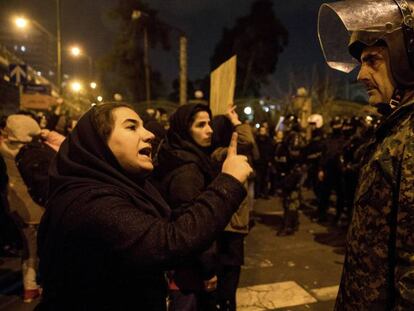 Una mujer se dirige a un policía durante la vigilia por las víctimas del vuelo de Ukraine International Airlines derribado por Irán que, este sábado, se transformó en una protesta antigubernamental. En vídeo, protestas en Irán y declaraciones del primer ministro canadiense.