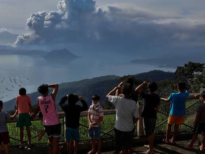 Un grupo de personas observa la erupción del volcán Taal este lunes en Tagaytay City (Filipinas). En vídeo, imágenes de la actividad del volcán.