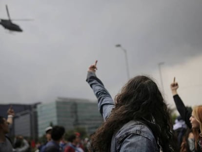 Manifestantes gesticulan contra un helicóptero de la policía. En vídeo, imágenes de las protestas en Bogotá