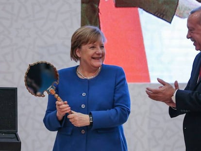 Merkel sostiene un espejo regalado por el presidente Erdogan, este viernes en Estambul.