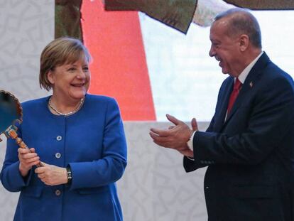 Merkel sostiene un espejo regalado por el presidente Erdogan, este viernes en Estambul.