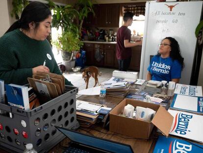 Una mesa de la campaña latina de Bernie Sanders. En video, Bernie Sanders durante un rally en Iowa.