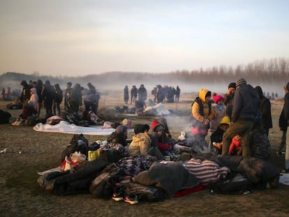 Unos migrantes se agolpan en la orilla del río Evros, este domingo cerca de Pazarkule (Turquía). En vídeo, un grupo de ciudadanos de Lesbos trata de impedir el desembarco de refugiados sirios.