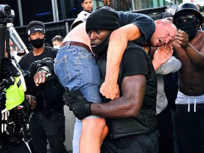 Patrick Hutchinson cargando a un hombre blanco agredido durante las manifestaciones y contramanifestaciones de Londres el pasado sábado. En vídeo, imágenes del rescate durante la manifestación y entrevista a Hutchinson.