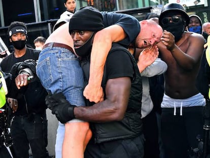 Patrick Hutchinson cargando a un hombre blanco agredido durante las manifestaciones y contramanifestaciones de Londres el pasado sábado. En vídeo, imágenes del rescate durante la manifestación y entrevista a Hutchinson.