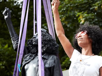 La activista antirracista Jen Reid posa con su estatua. En vídeo, la historia de la estatua crada por el artista Mar Quinn.