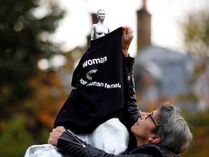 En la imagen, una activista viste con una camiseta la escultura en señal de protesta. En el vídeo, la escultura en su entorno, un parque de Londres.
