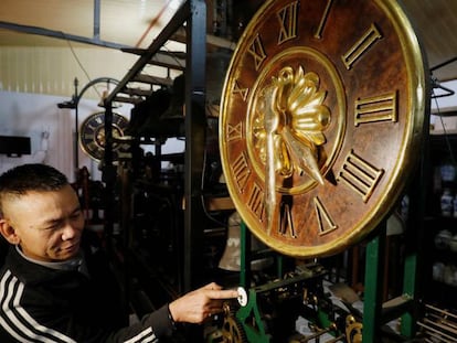 El coleccionista de relojes Pham Van Thuoc, con uno de los aparatos restaurados en su taller de Vietnam.