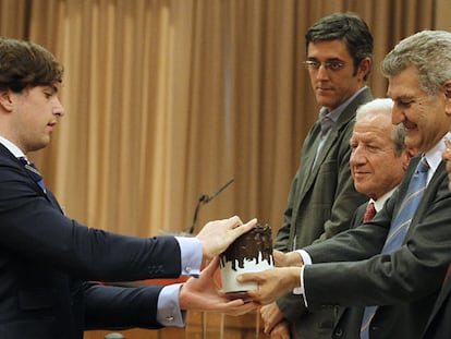 Fernando Fraga, nieto de Manuel Fraga, recoge la escultura 'El Abrazo', en el homenaje de la Cámara a los padres de la Constitución. / KOTE RODRIGO (EFE)