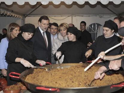 Rajoy observa cómo se preparan las migas del pastor que se sirvieron en la cena del PP de Madrid.