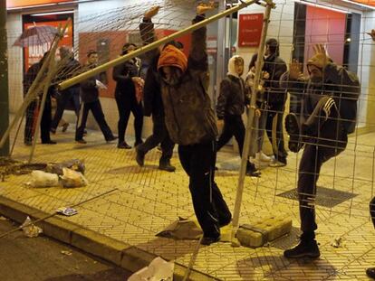 Tres jóvenes tiran una valla en los altercados ocurridos en Gamonal en la noche del sábado al domingo.