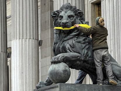 Greenpeace amordaza durante segundos los leones del Congreso de los Diputados