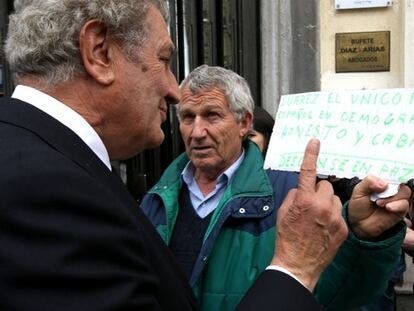 Jesús Posada, presidente del Congreso, junto a un ciudadano que espera su turno para despedirse del presidente Adolfo Suárez.