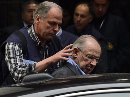 Rodrigo Rato, introducido en el coche de los agentes de Aduanas.