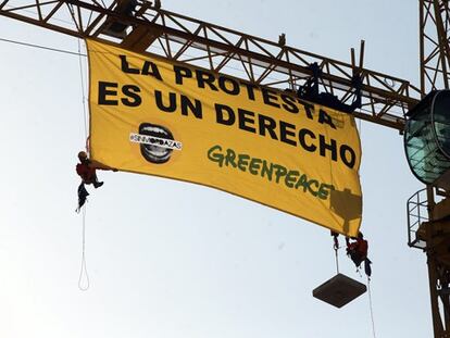 Activistas de Greenpeace colocan una pancarta contra la 'Ley Mordaza' junto al Congreso.