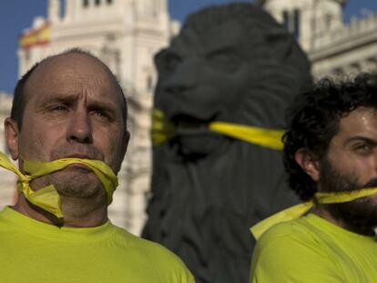 Dos manifestantes protestan por la 'ley mordaza'.