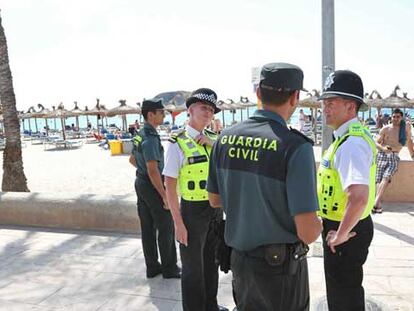 Miembros de la Guardia Civil y 'Bobbies' británicos patrullan por la playa de Magaluf.