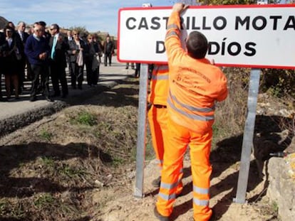 Un operario, este viernes, con el cartel de la nueva nomenclatura del pueblo.