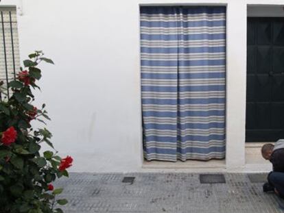 Un cámara toma imágenes de manchas de sangre a la puerta de la vivienda en la que ha tenido lugar el suceso.