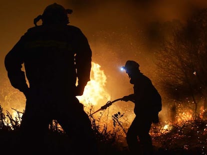 Bomberos luchan contra el fuego en un bosque cercano a Berango (Vizcaya), este lunes.