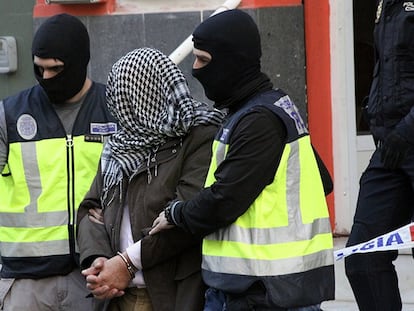 La policía traslada a uno de los detenidos en Ceuta este domingo.