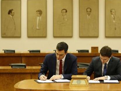 Sánchez y Rivera firman el acuerdo al que han llegado ambas formaciones, el miércoles en el Congreso. LUIS SEVILLANO
