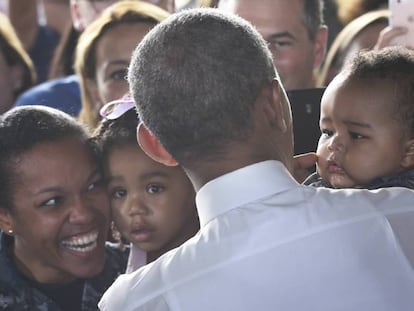 Obama toma en brazos a un niño en la Base naval de Rota.