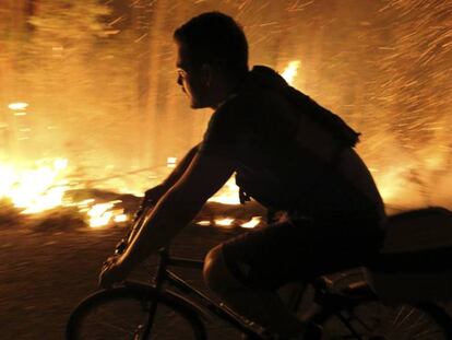 Un vecino intenta sofocar las llamas del incendio forestal en Pontevedra.