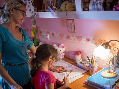 Almudena, de cinco años, rellena las fichas con las letras del abecedario con la ayuda de su madre.