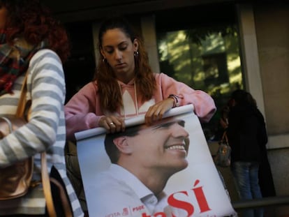 Una simpatizante enrolla un póster de Pedro Sánchez este sábado.