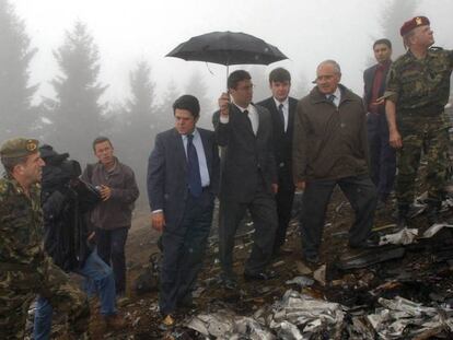 El entonces ministro de Defensa, Federico Trillo, con chaqueta azul, en el lugar del accidente, el 27 de mayo de 2003. En vídeo, las reacciones del presidente, Mariano Rajoy, al informe del Consejo de Estado.