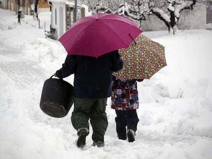 Dos vecinos van a coger nieve, este jueves en Famorca (Comunidad Valenciana).