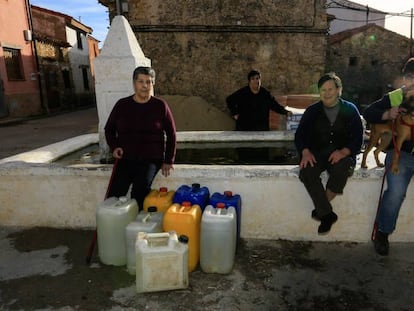 Todos los vecinos que viven en el pueblo de Toril (Teruel) posan mientras recogen agua de la fuente.