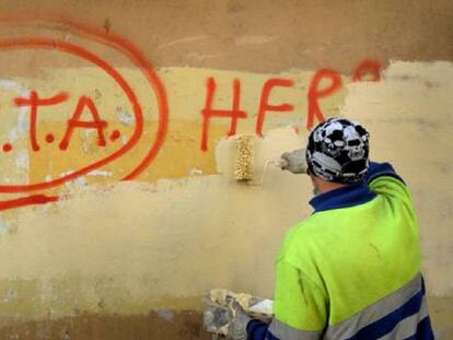 Un trabajador tapa una pintada a favor de ETA en 2011 en Gernika.