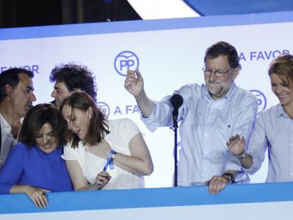 El líder del PP y candidato a la presidencia, Mariano Rajoy, saluda a sus seguidores desde la sede de Génova. En vídeo, declaraciones de Soraya Sáenz de Santamaría sobre la encuesta de EL PAÍS.