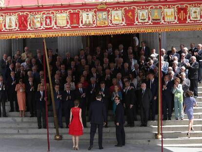 Parlamentarios de las Cortes Constituyentes de 1977, junto a Mariano Rajoy y otros cargos actuales, aplauden a los Reyes, en la escalinata de entrada al Congreso.
