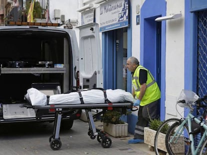 Un empleado de una funeraria saca el cadáver de un hombre.