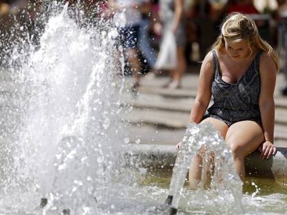 Unos turistas se refresca en una fuente en Valencia.