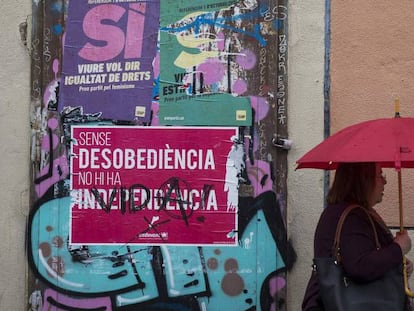 Una mujer pasa ante un cartel del publicidad del referéndum del 1 de octubre en una calle de Barcelona.