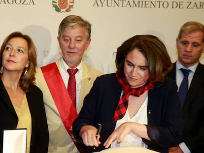 Colau firma en el Libro de Oro de Zaragoza el sábado. Detrás de ella, con la banda, Pedro Santisteve, alcalde de la ciudad.