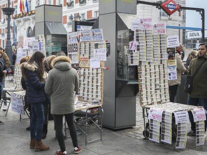 Puesto de venta de loteria en la Puerta del Sol de Madrid. En vídeo, los primeros asistentes al sorteo.